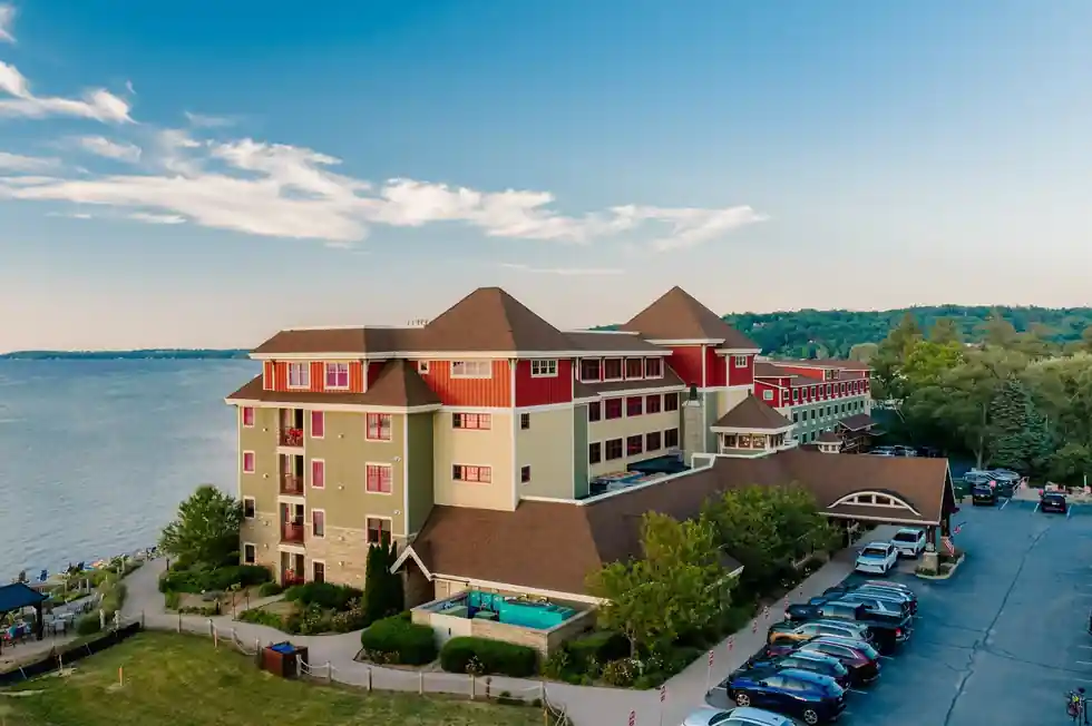 Aerial view of the lodge from the bay side, with the pool deck and parking beside the long wings