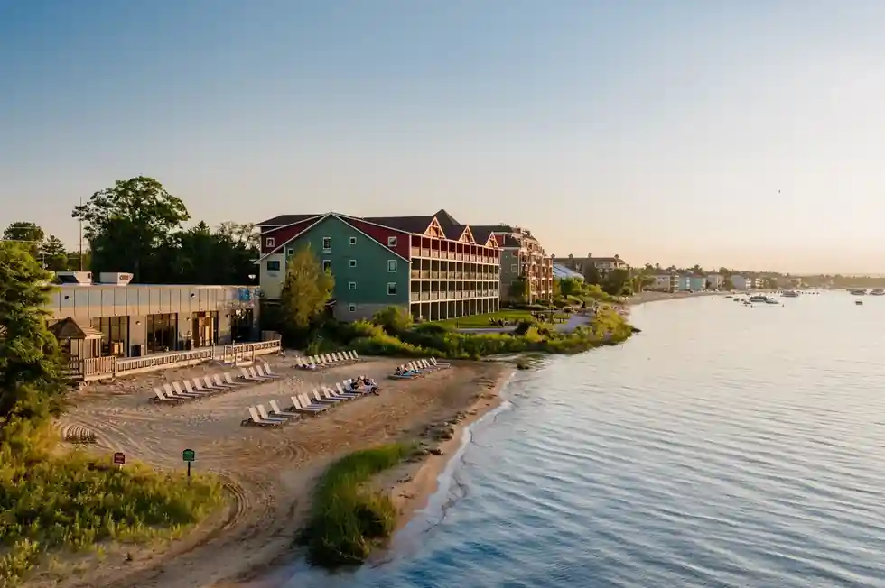 The beach and the lodge at golden hour, seen from above the water