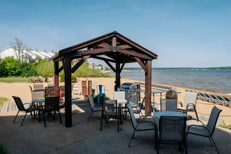 Timber pavilion, patio tables and grills on the beach, East Bay behind