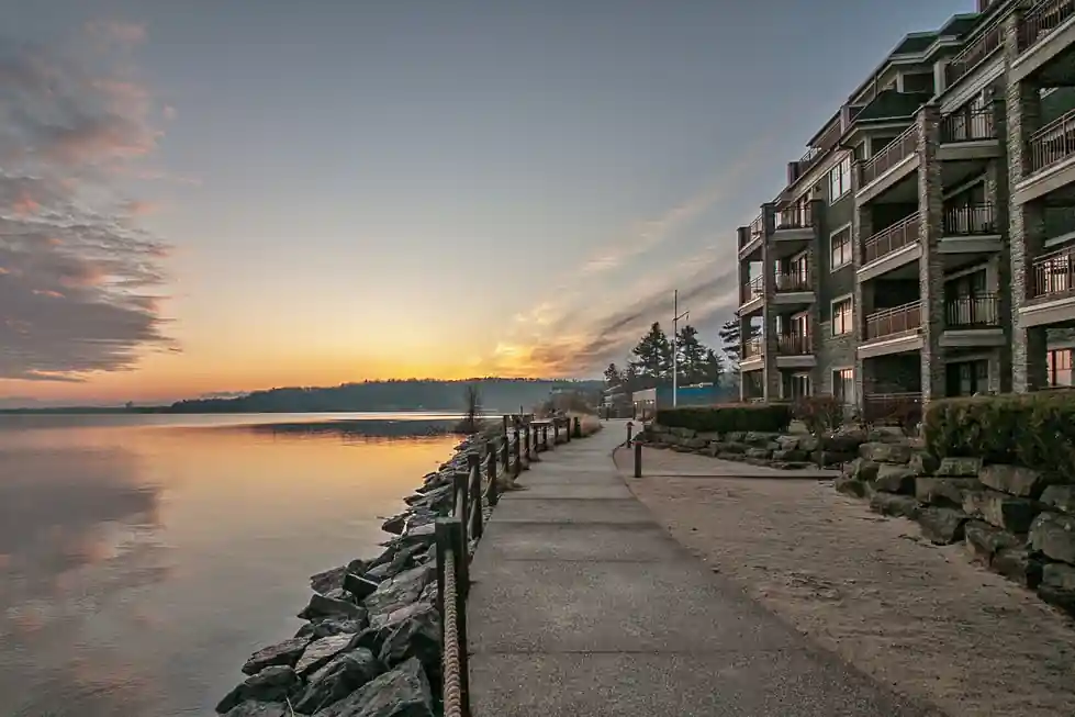 Lakeside walk beside the stone condominium wing at sunset