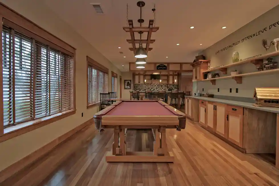 Billiards table in a long wood-paneled room