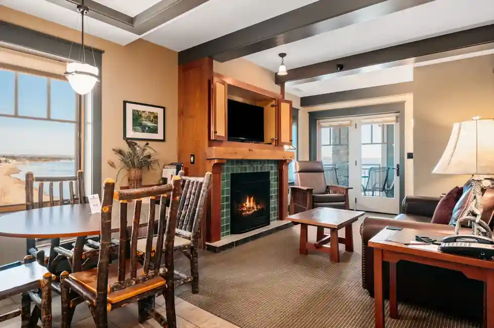 Suite living room with a tiled fireplace, dining table and a window onto the beach