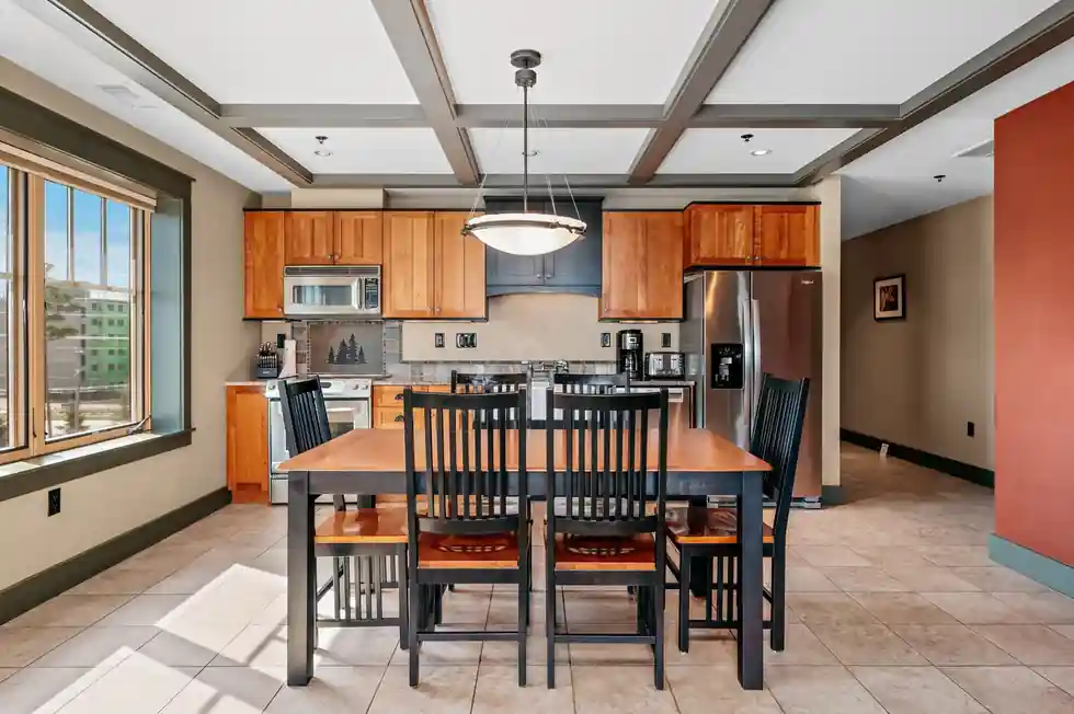 Suite kitchen with cherry cabinets and a stainless refrigerator, the dining table beyond