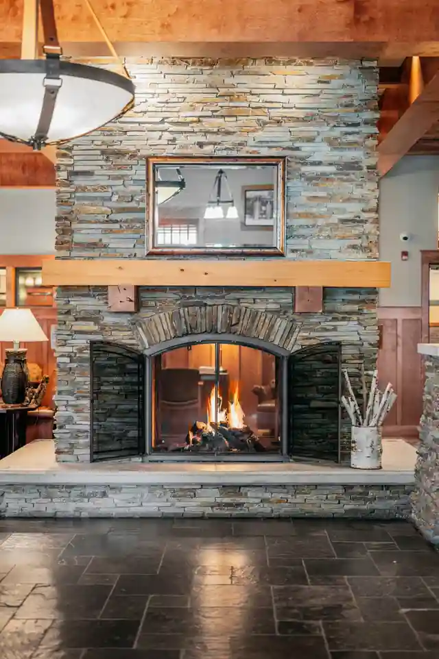 Fieldstone fireplace rising through the lodge